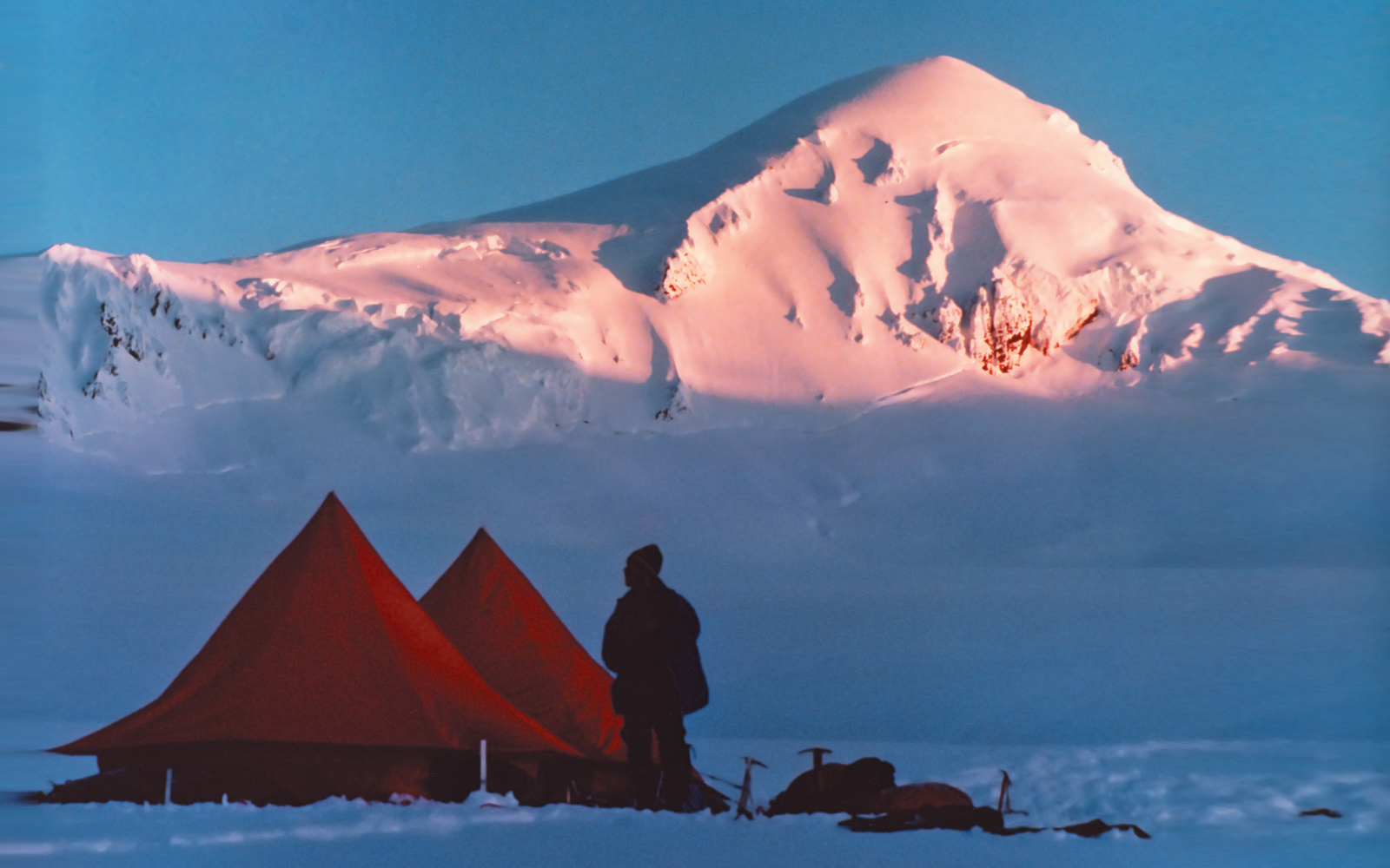 A rare, heartening sunshine falls on Mount Denison on the morning of the final ascent—a welcome sight to the weather-worn climbers.