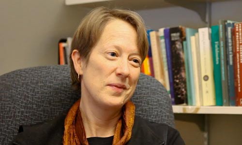 Elisa Kent in front of a bookshelf