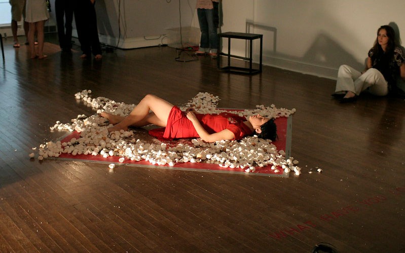 Woman laying on ground in red dress