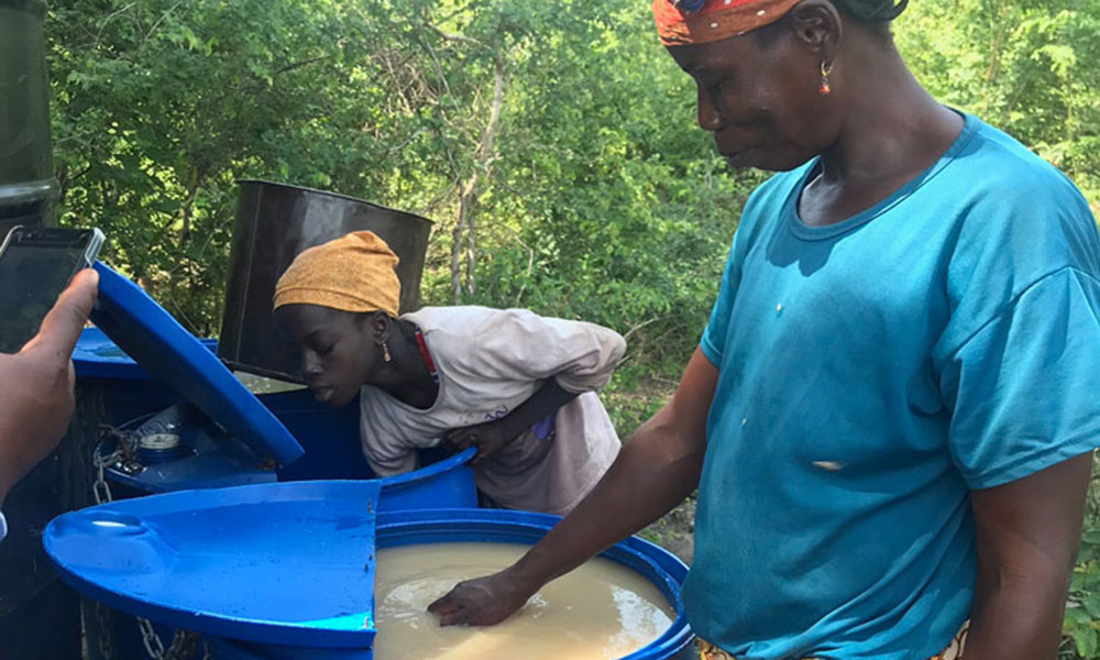 Person with hand in water container