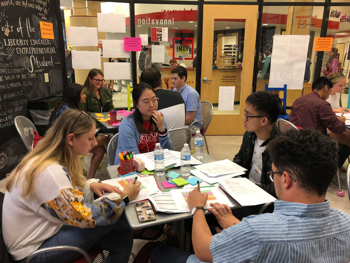 Four students at a table in the Red Frame lab