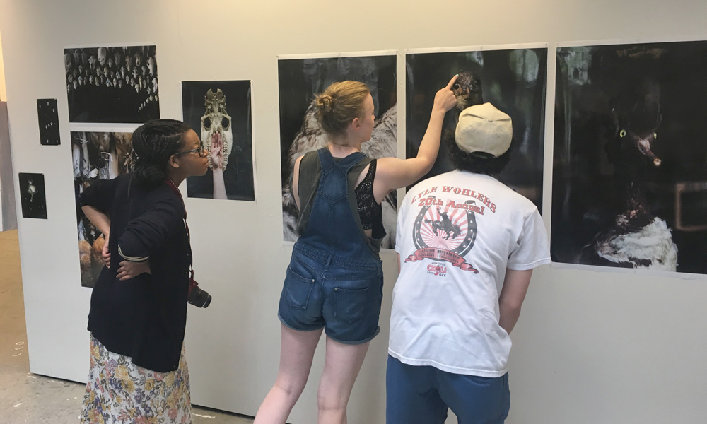 Ivy Distler, Matt Dumon, Hollie Davis in a group critique looking at Ivy's photographic work