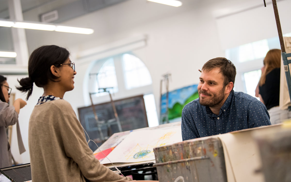 Student in conversation with professor Keith Spencer