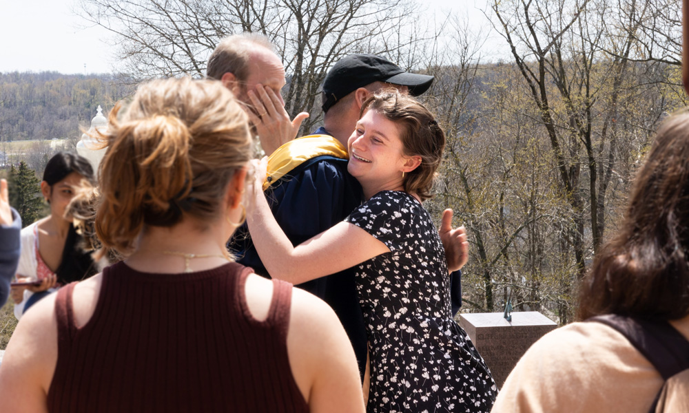 Sarah Hume ’22 embraces Jack Shuler, chair of the journalism major.