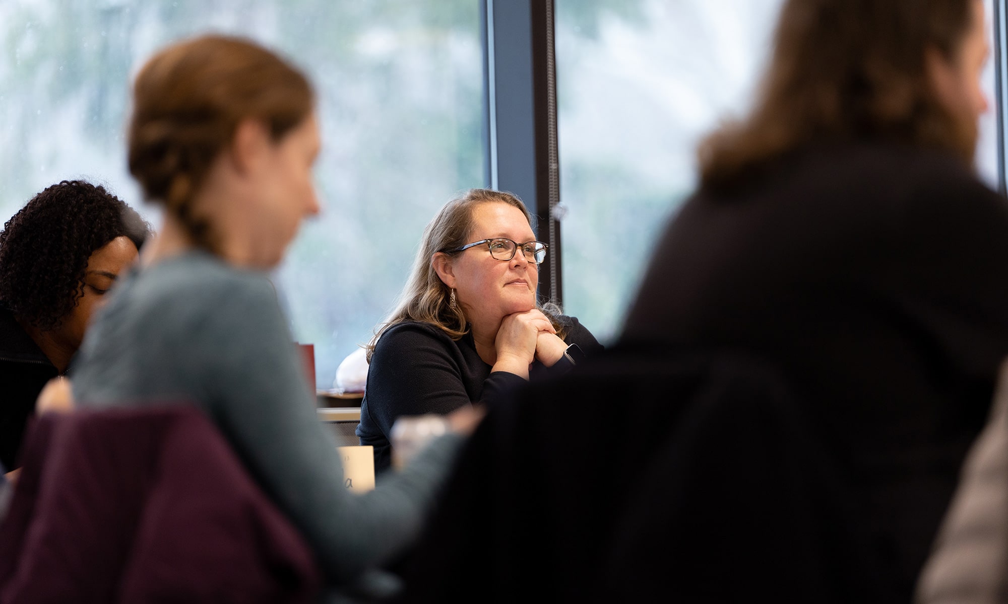 Rebecca Homan in a room with other faculty members