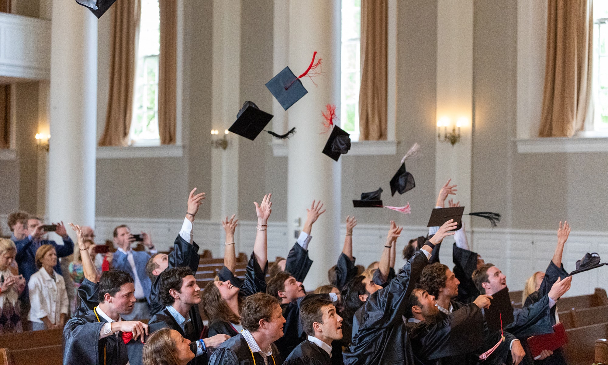 Lacrosse graduates tossing their caps