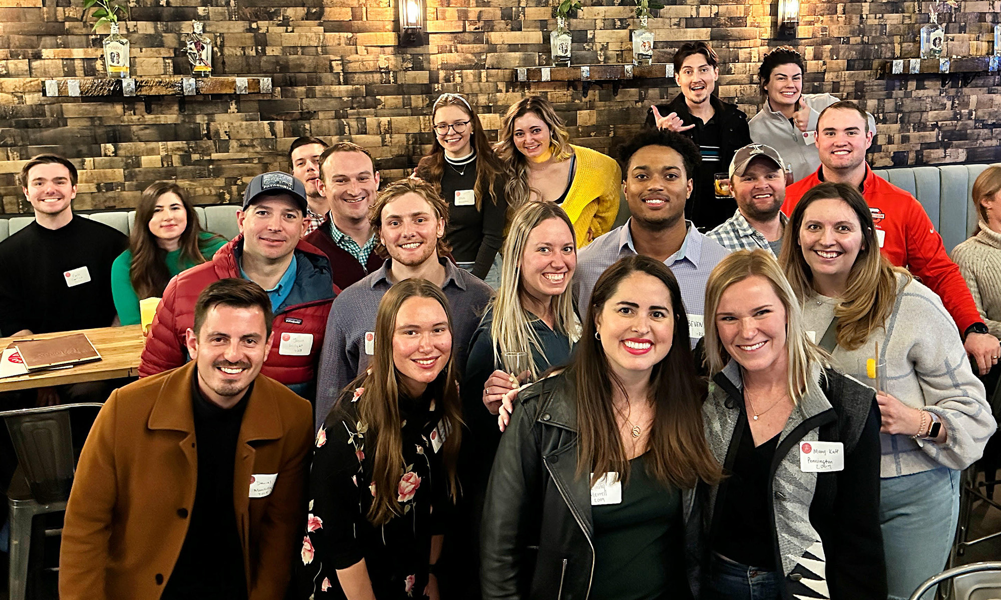 A group of Denison alums gathered at a restaurant posing and smiling for the camera