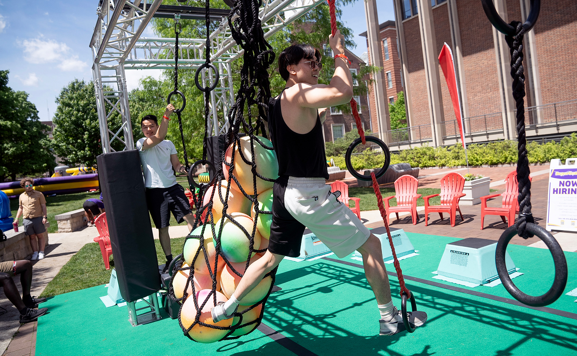 A man climbing a ring course as part of senior games. 