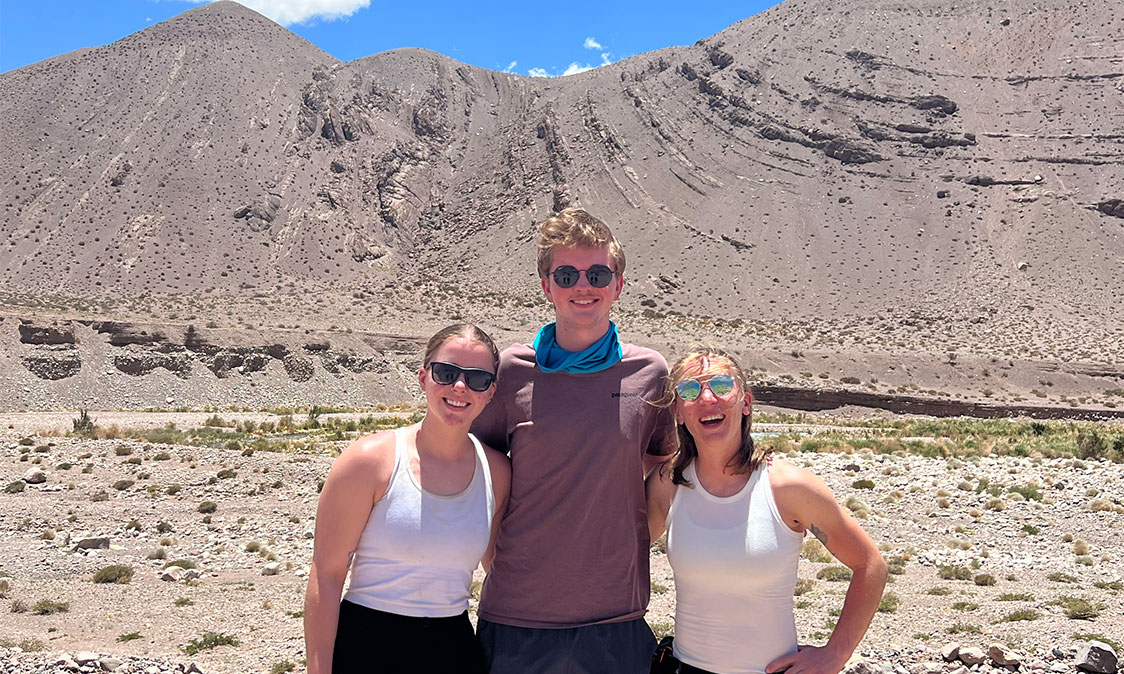 People posing in front of a mountain