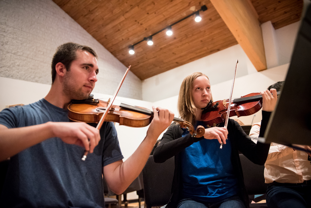 Two musicians playing violin side by side