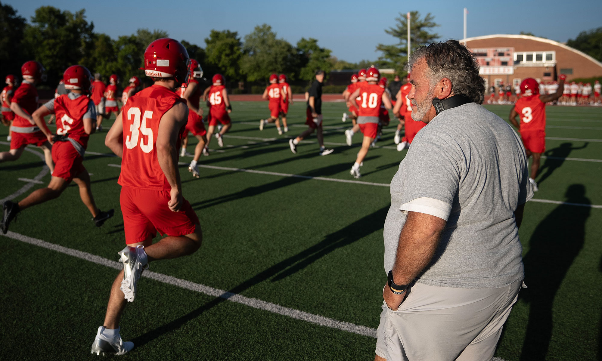 Coach Jack Hatem watches players practice on Deeds Field.