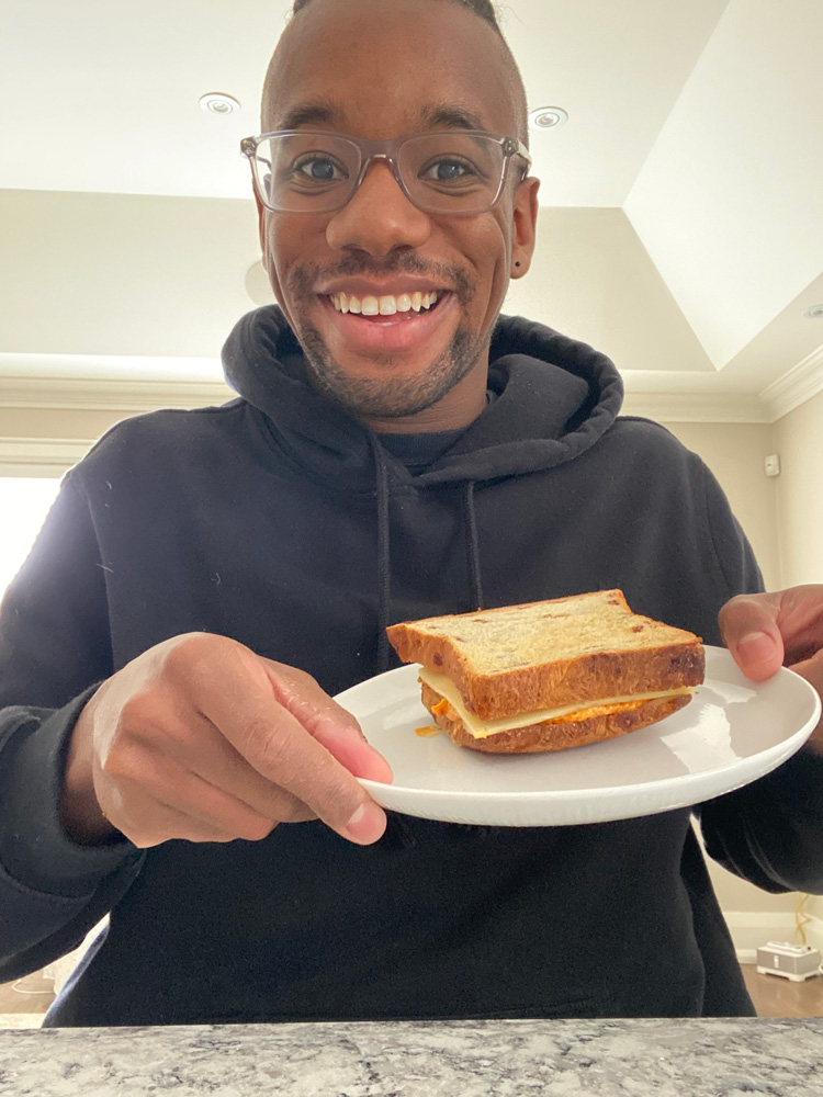 Christien Kelly holding a plate with a sandwich on it.