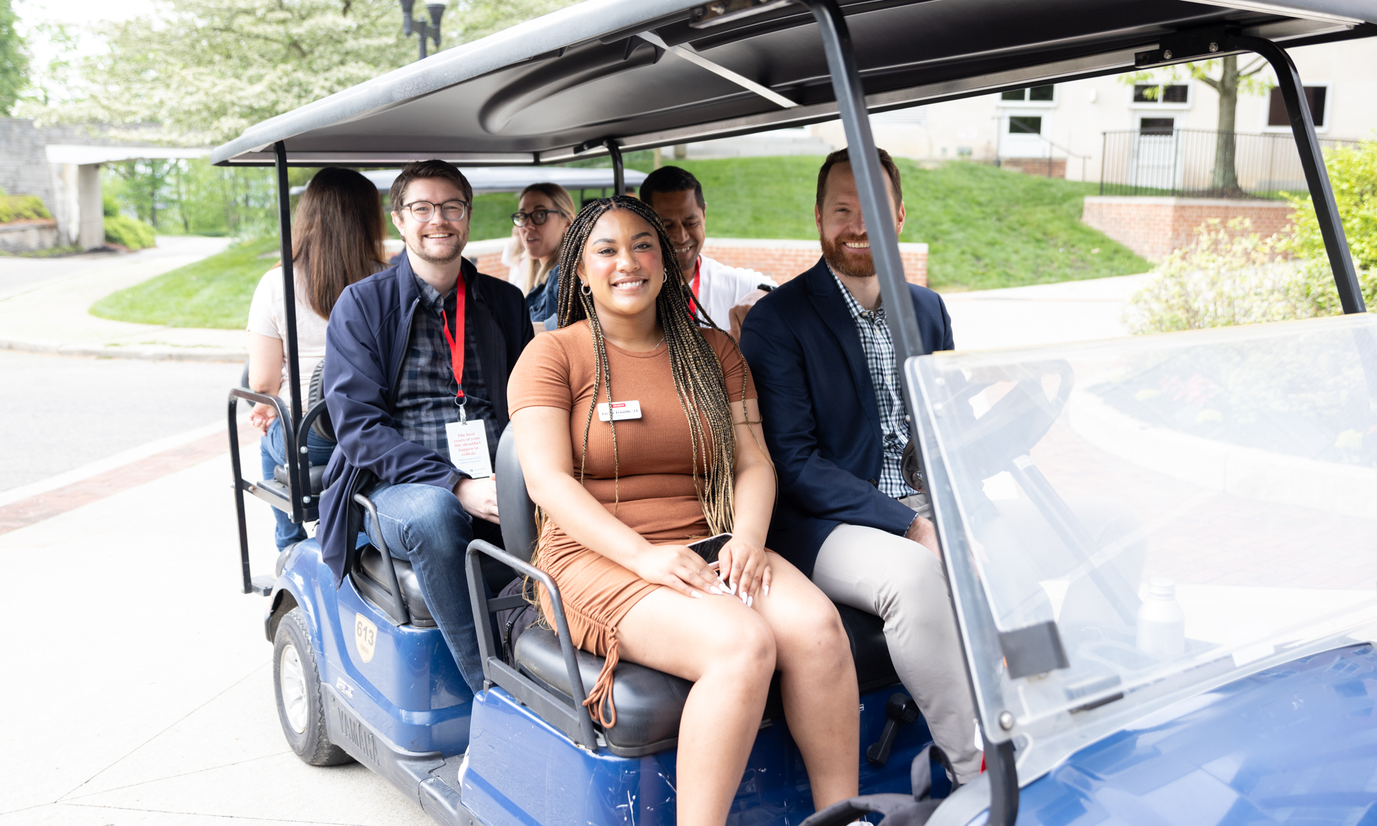 Taylor Trimble rides on a golf cart with fellow Denisonians.