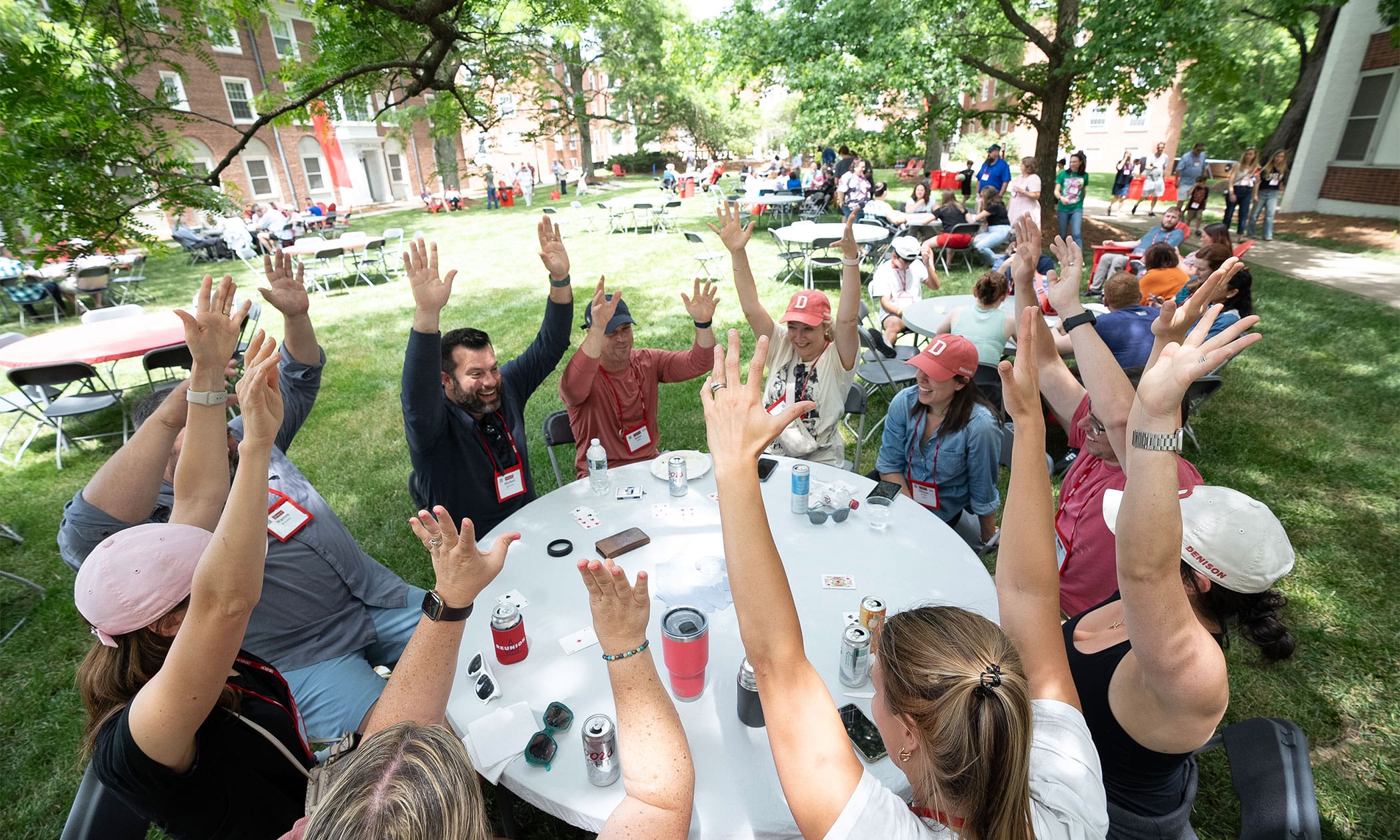 People sitting around a table with their hands up