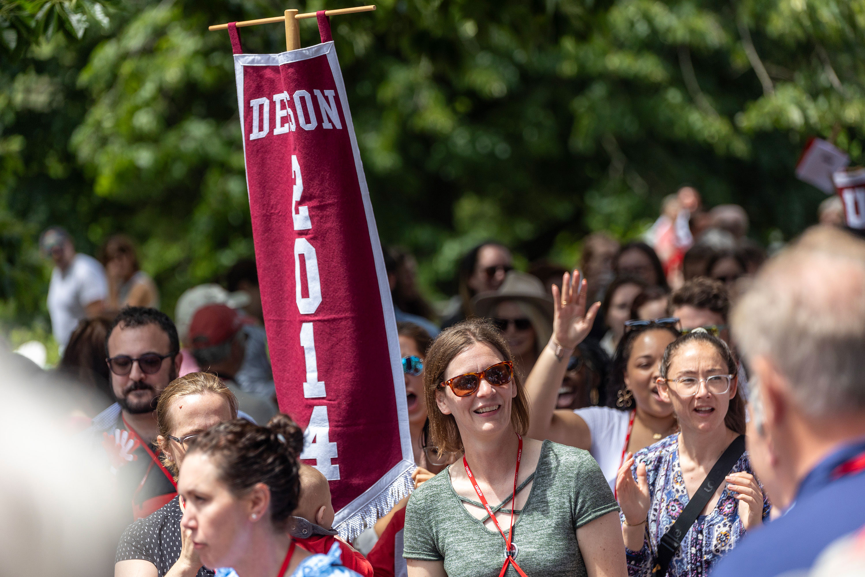 Group of people walking together. Someone in the middle is holding a banner that says 2014.