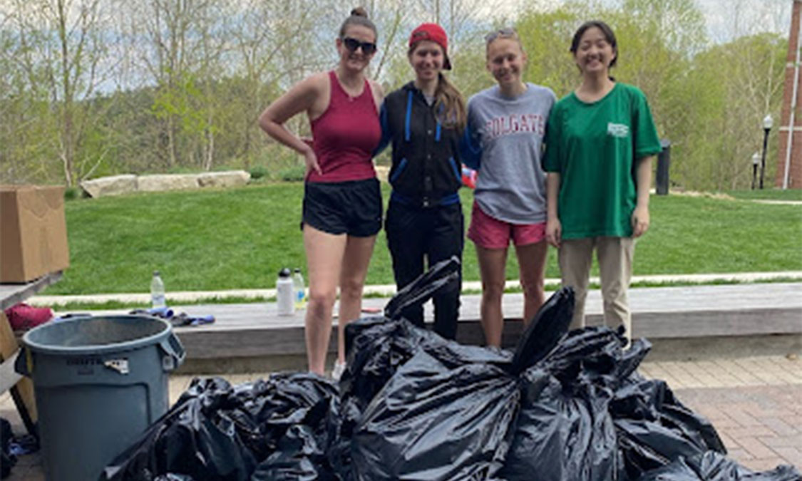 Women standing behind collected trash