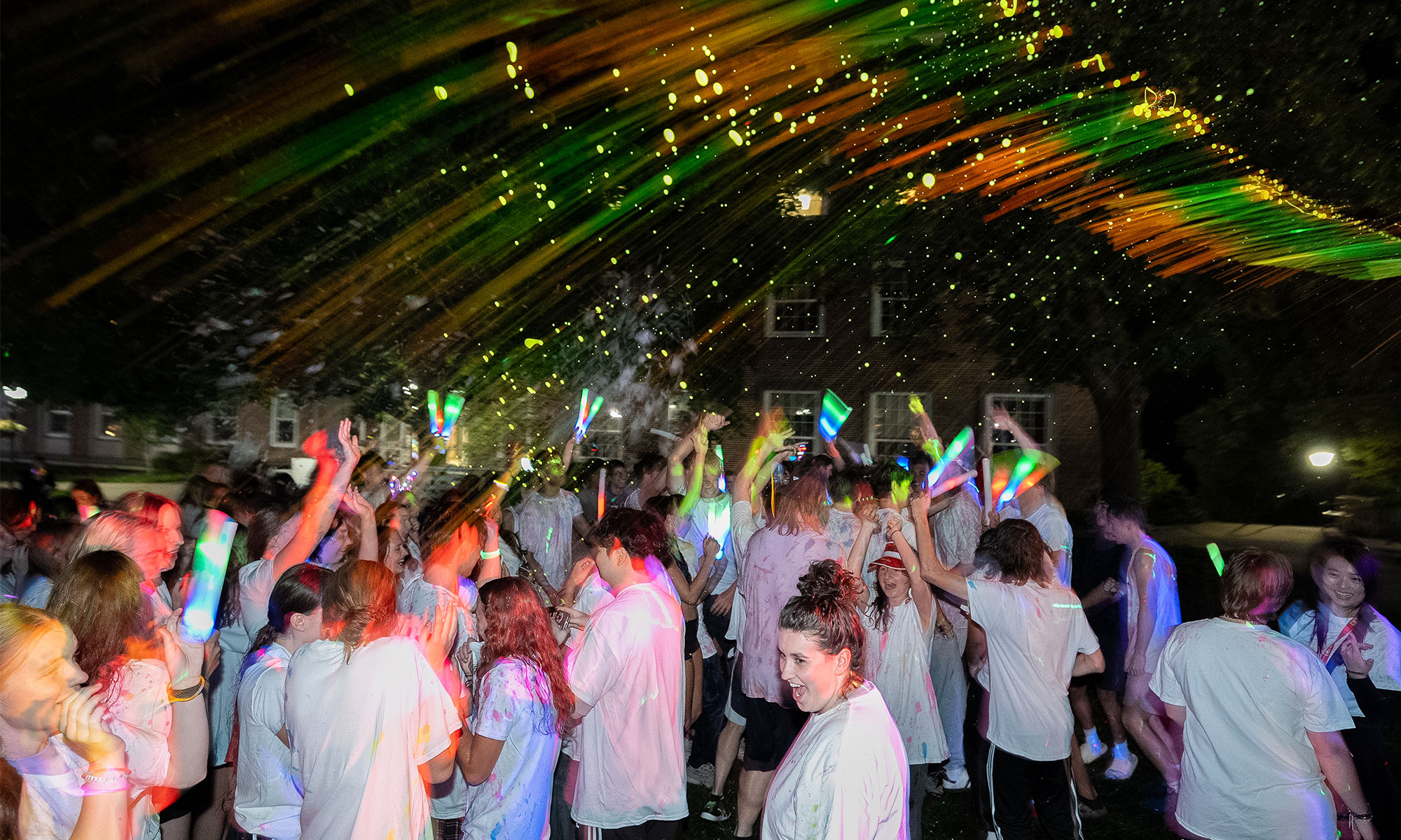 Students dancing as paint is sprayed in the air