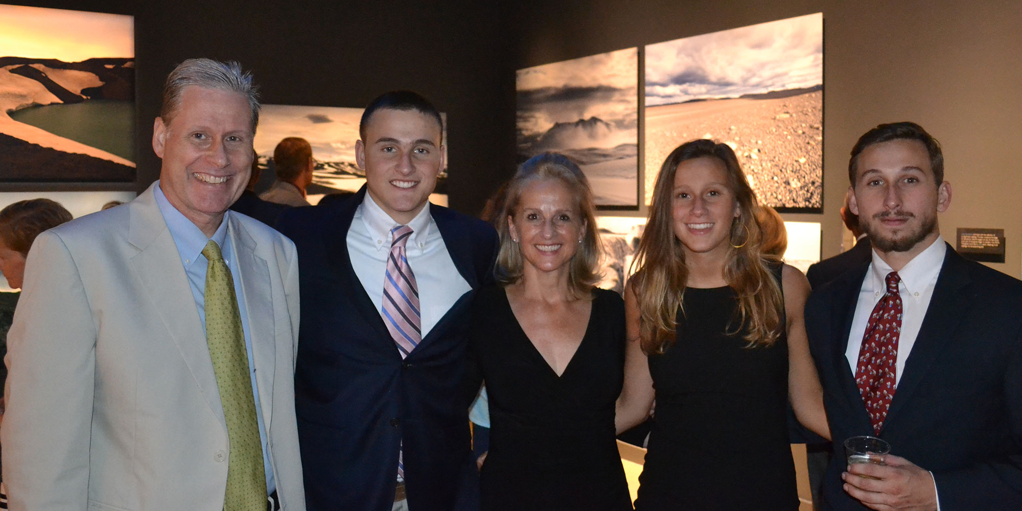 Man and his family posing for a photo. They are dressed up and smiling.