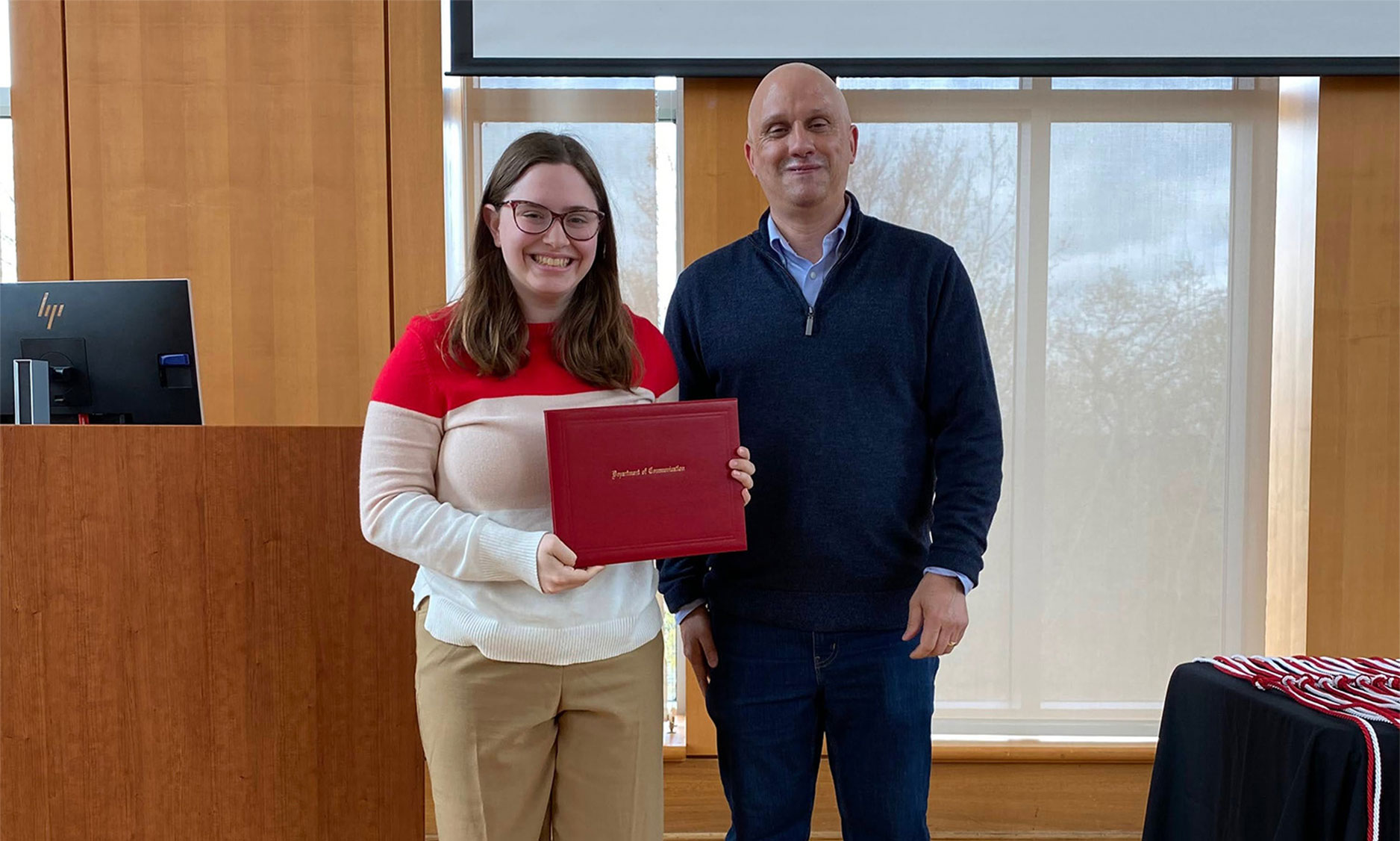 Student holding award with professor