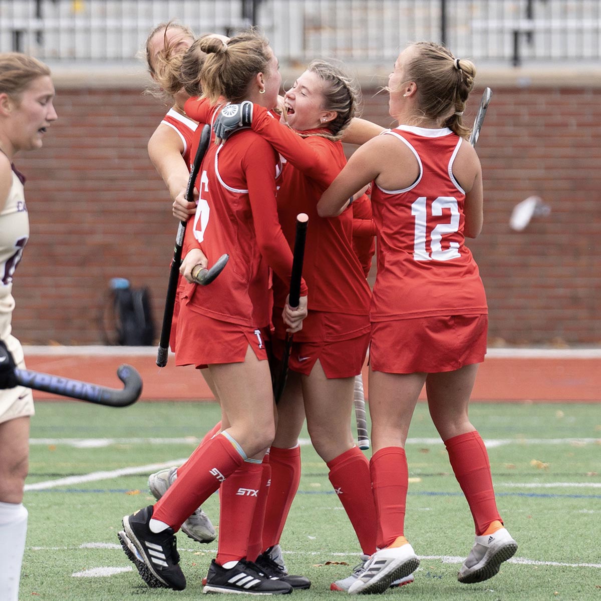 Women's field hockey team celebrates victory.