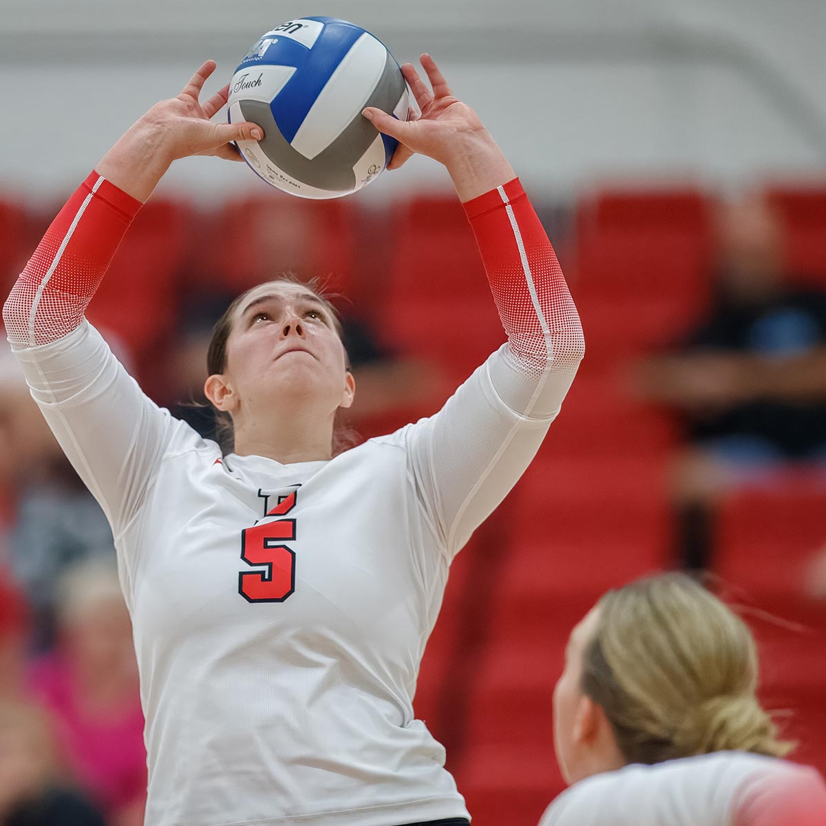 Denison volleyball player setting the ball in play.