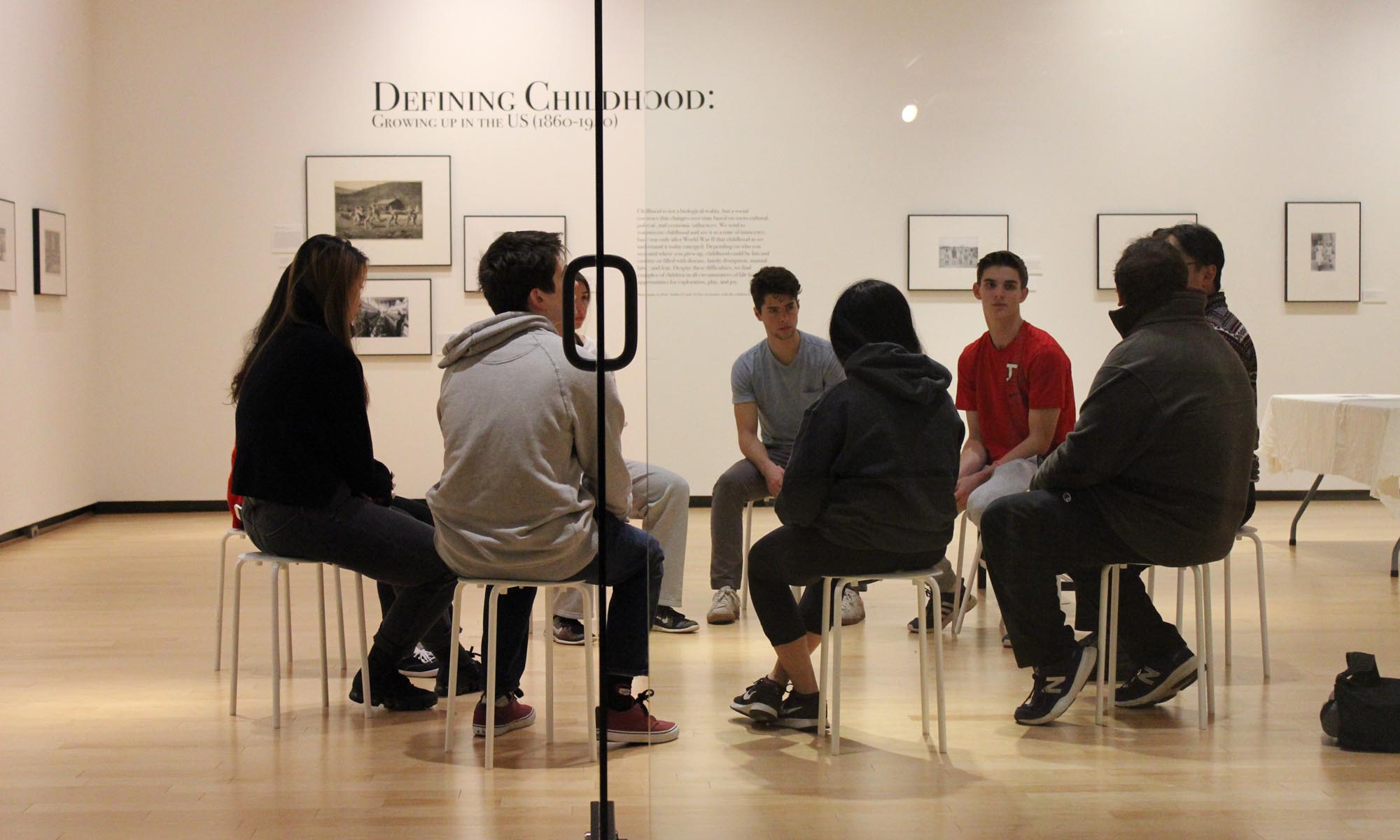 Students and faculty gathered in a circle discussing an exhibition.