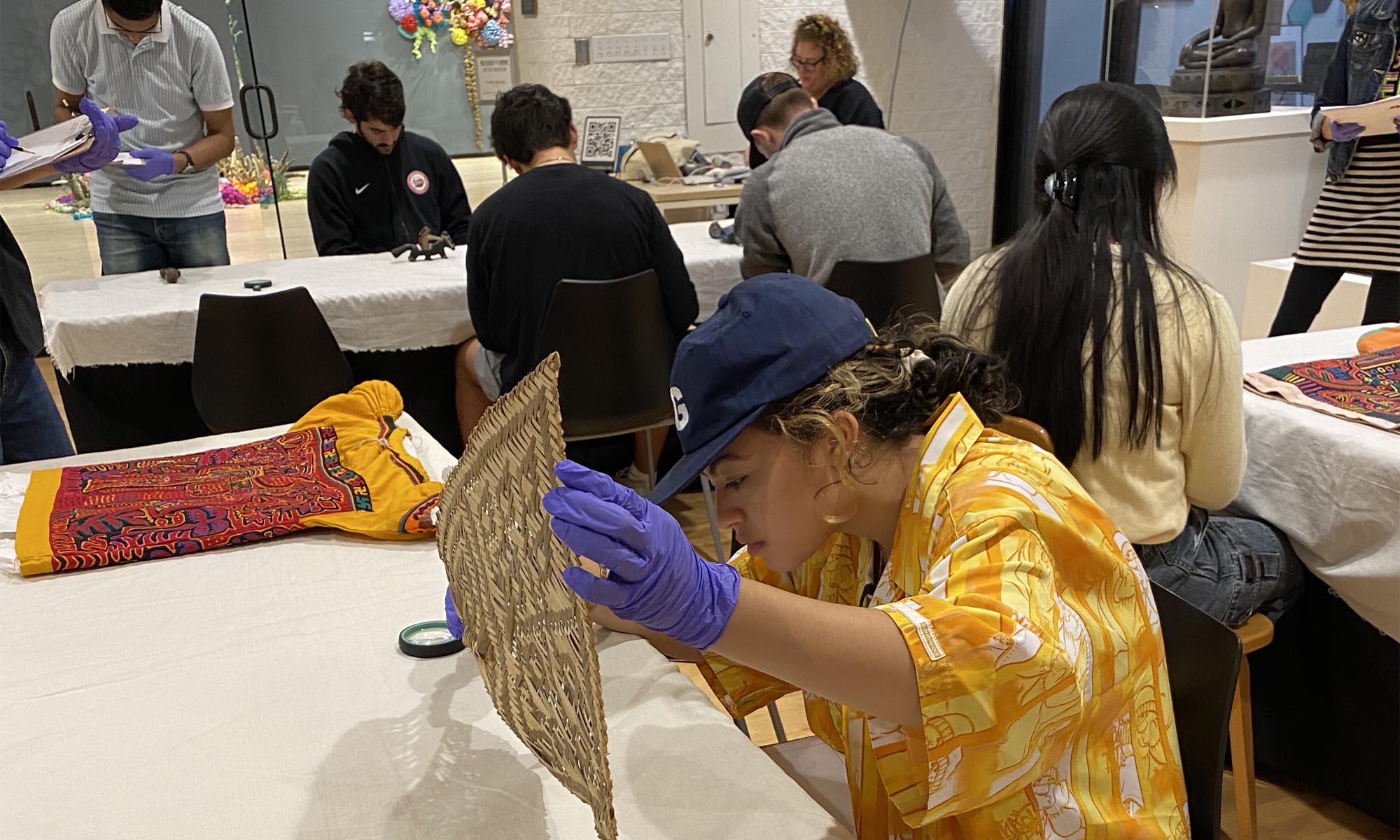 Students examining pieces from the Museum's  Hispanic/ LatinX art collection