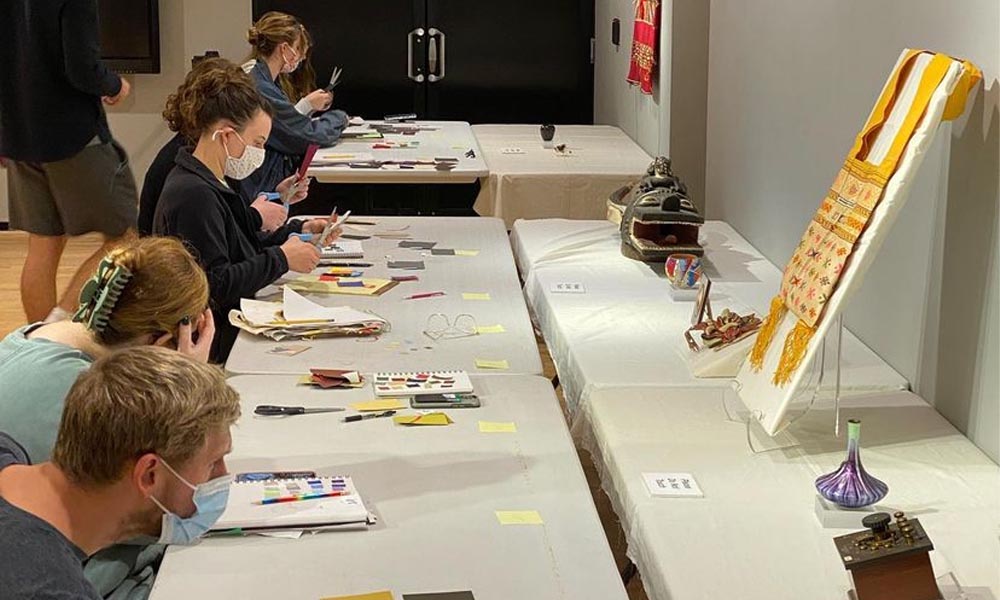 Students sitting at an art table create their own color wheels.