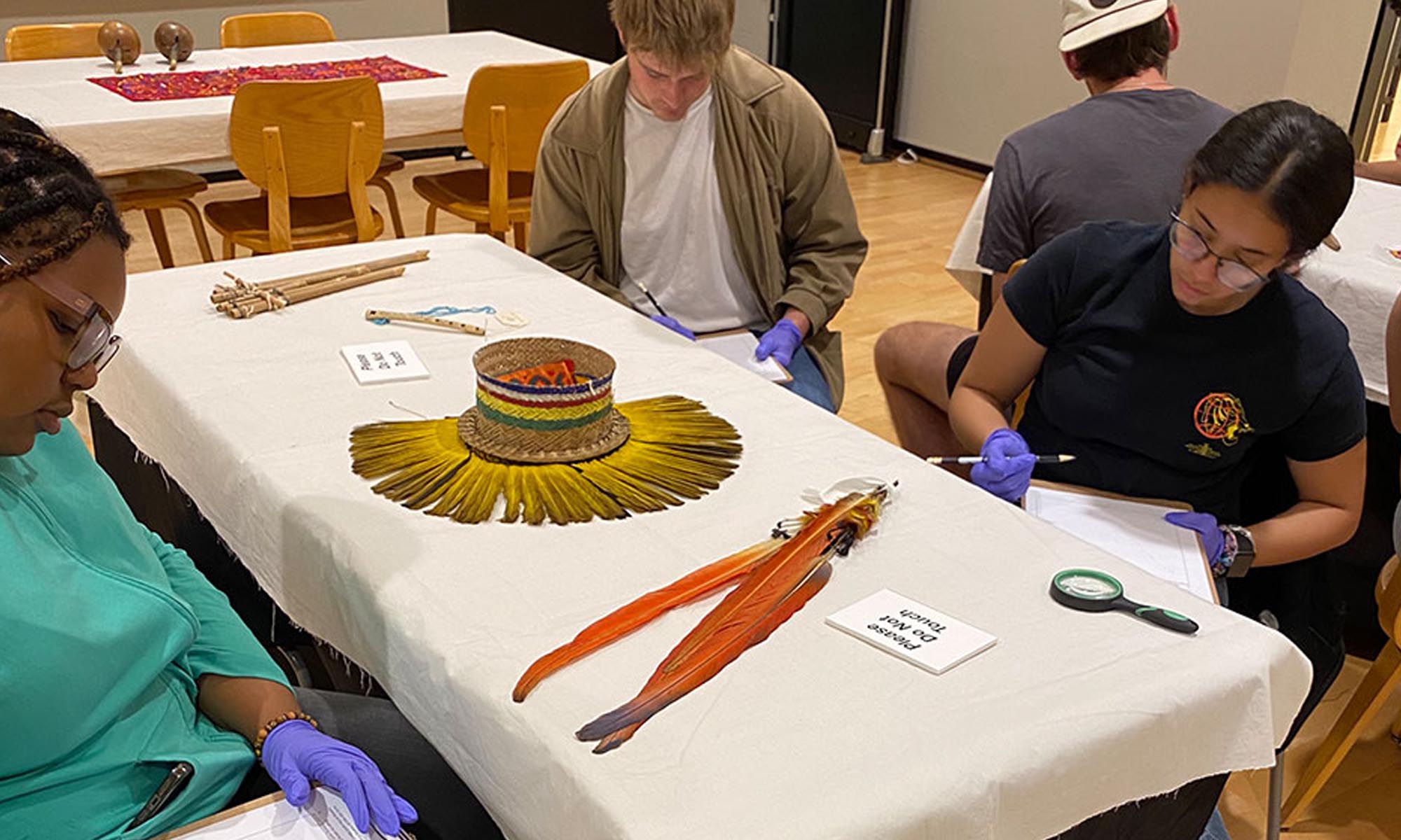 Students sitting around a table analyzing Guna Indians' mola textiles. 