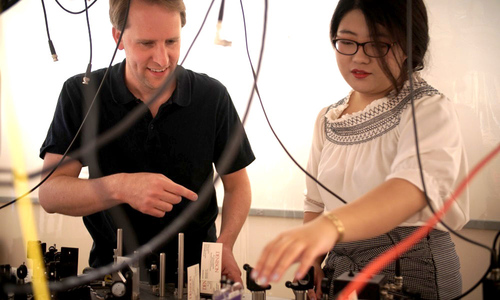 Olmschenk in his lab with a student