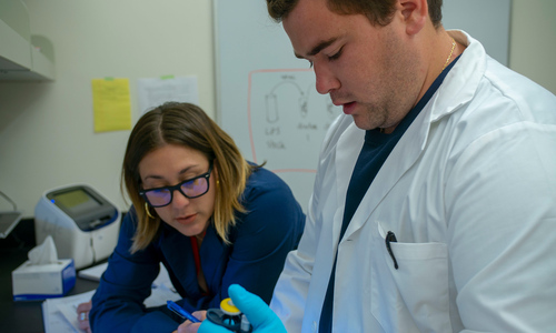 Summer Scholar Science: Assistant Professor Cristina Caldari monitors the work of Jordan Beck.