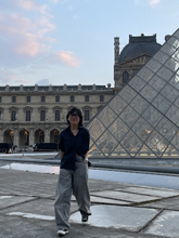 Photo of HeeYoung Chae outside the Louvre Museum in Paris, France.