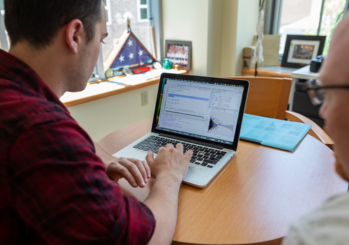 Michael Brady, the outgoing associate director of data analytics, works with a student.