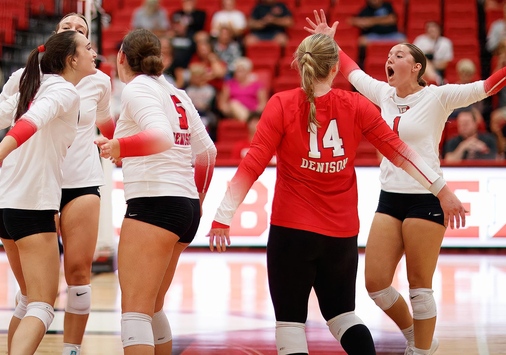 Denison's volleyball team celebrating a win.