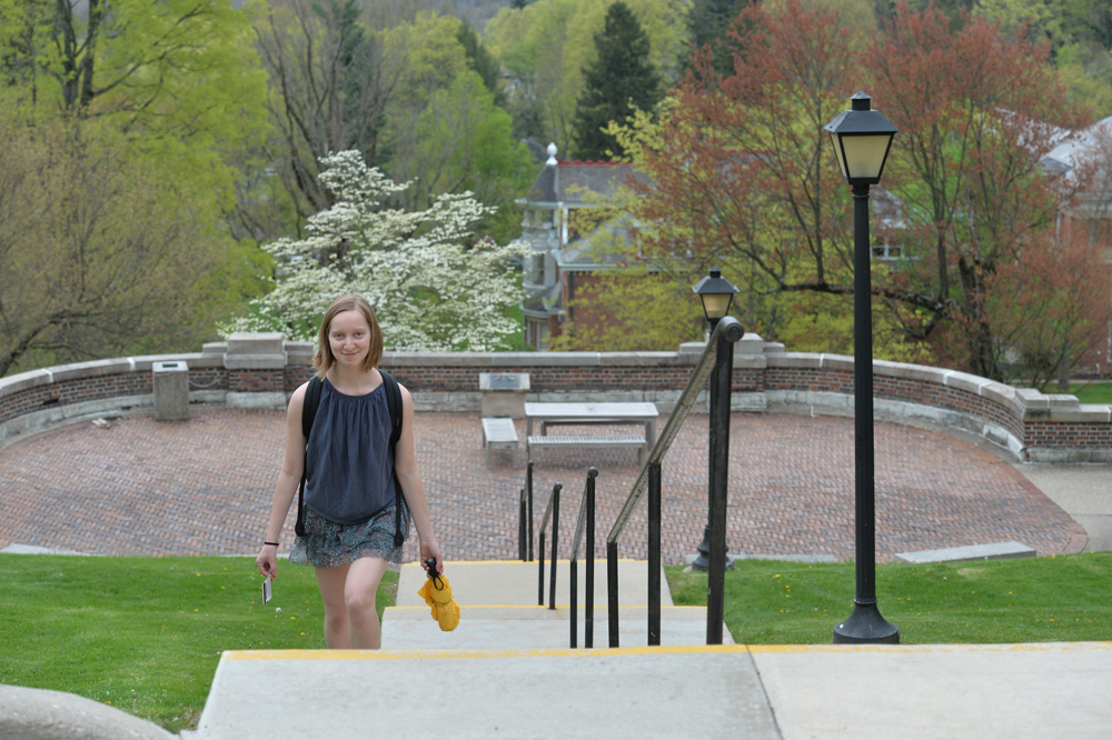 student walking up stairs with trees in the background