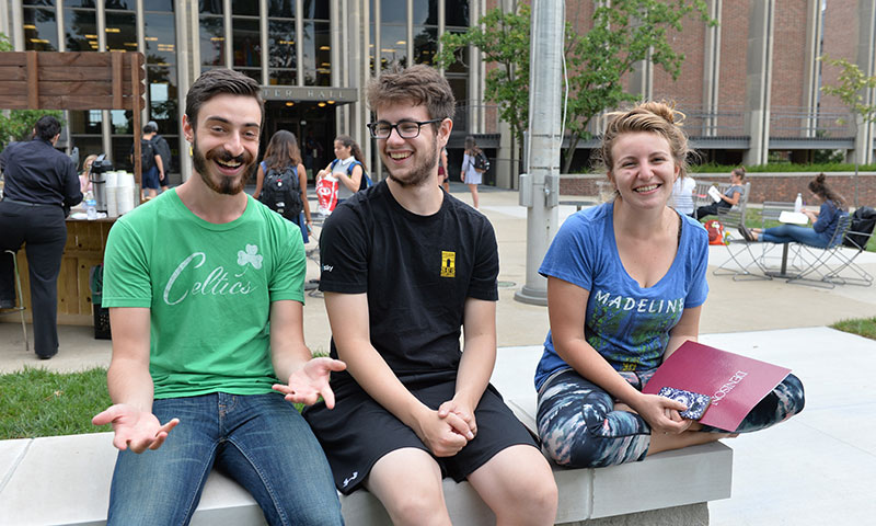 Denison students sitting on a wall