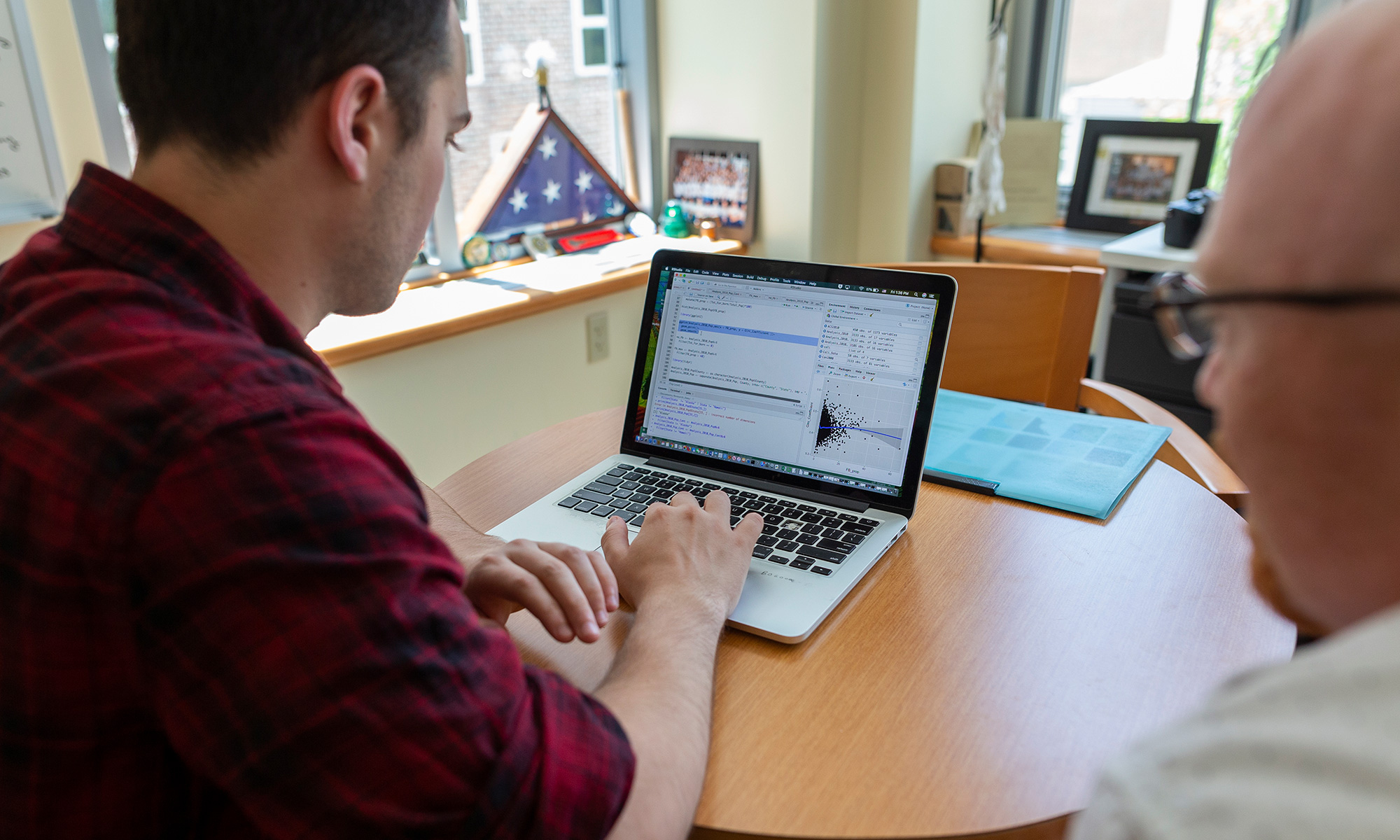 Michael Brady, the outgoing associate director of data analytics, works with a student.