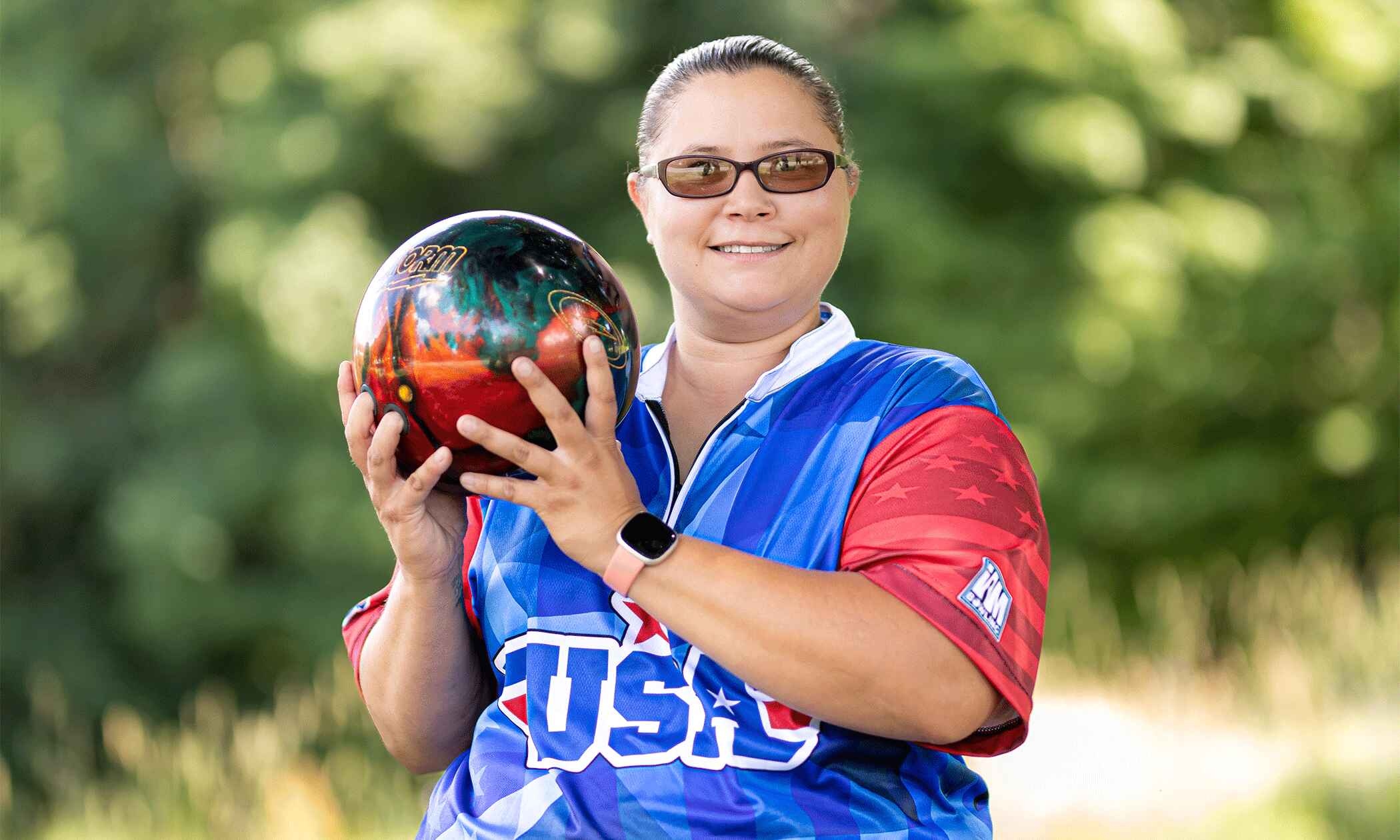 Jerrica in her bowling uniform holding a bowling ball