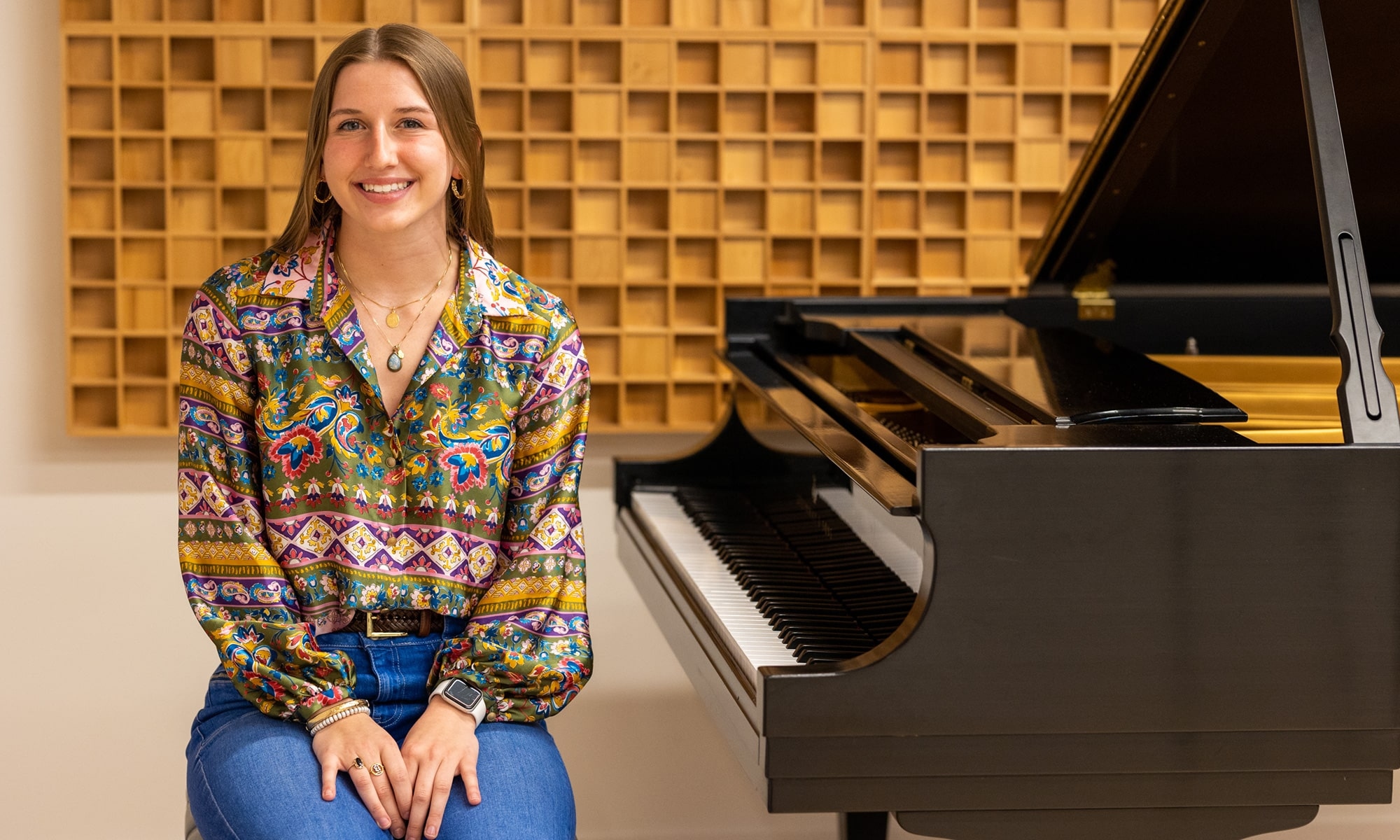 Ellie Blasko '23 sitting next to a piano