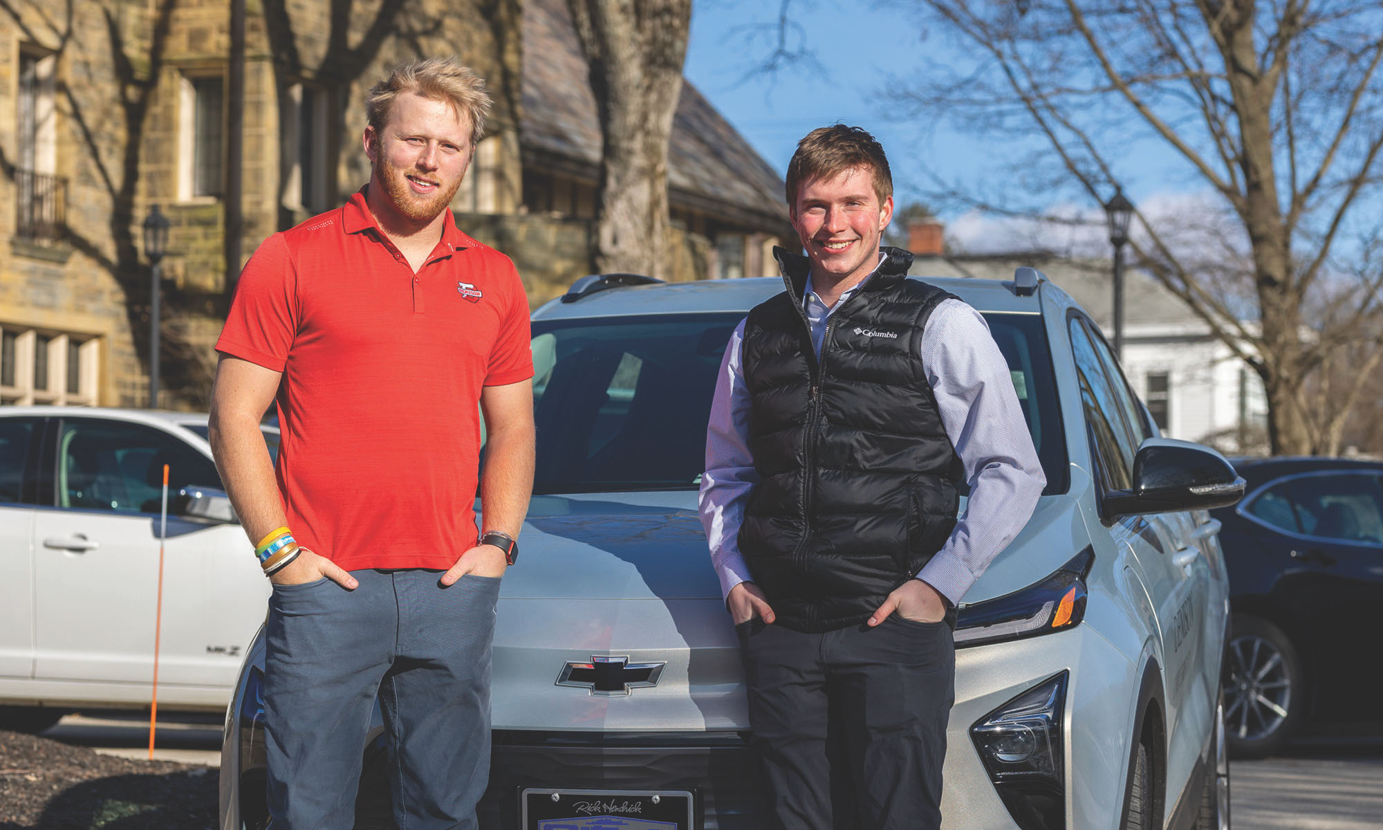 Colin Ravin ’24, left, and Chase King ’24 stand in front of Denison’s new Chevy Bolt.