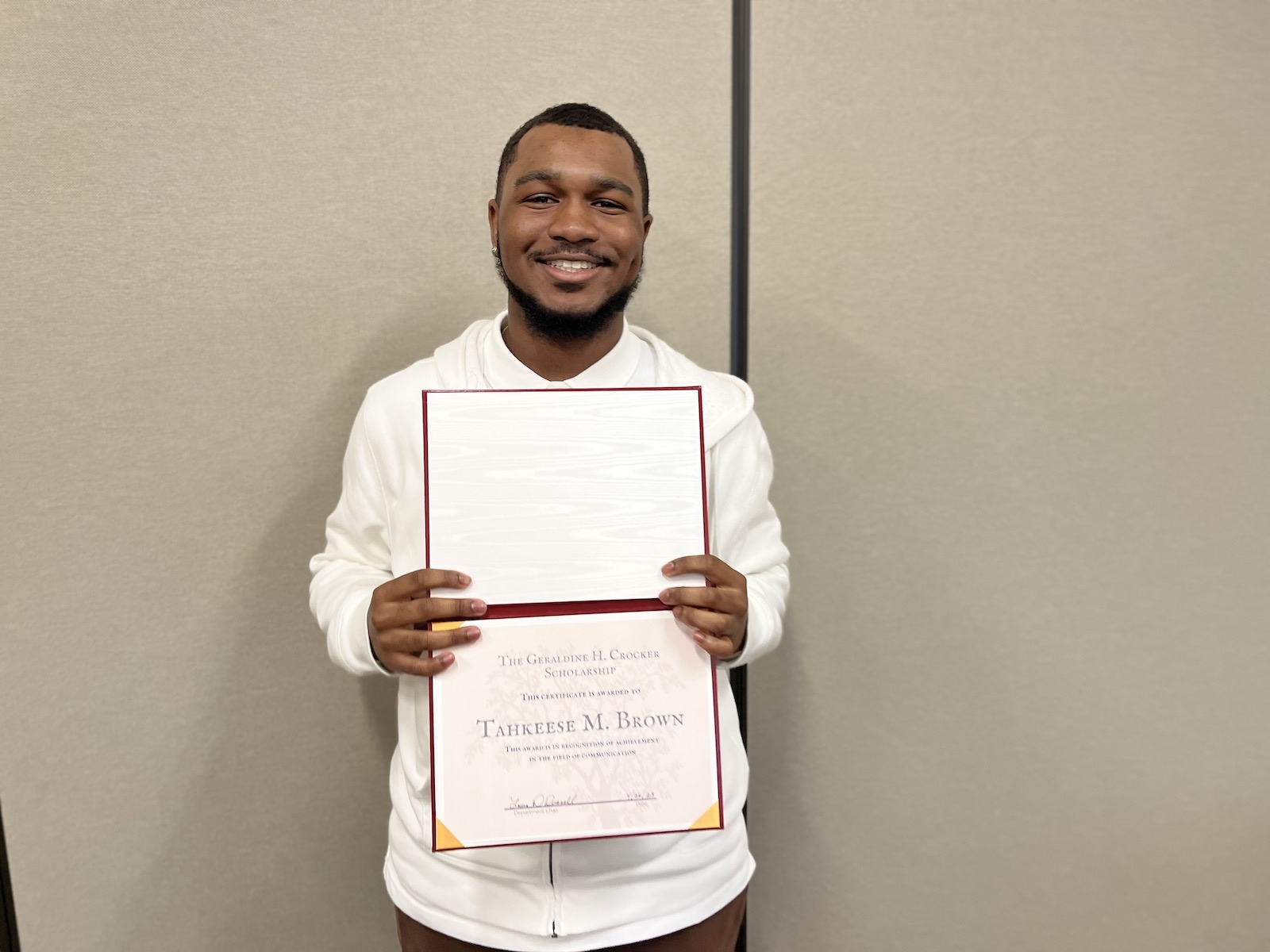 Tahkeese M. Brown holding his awards