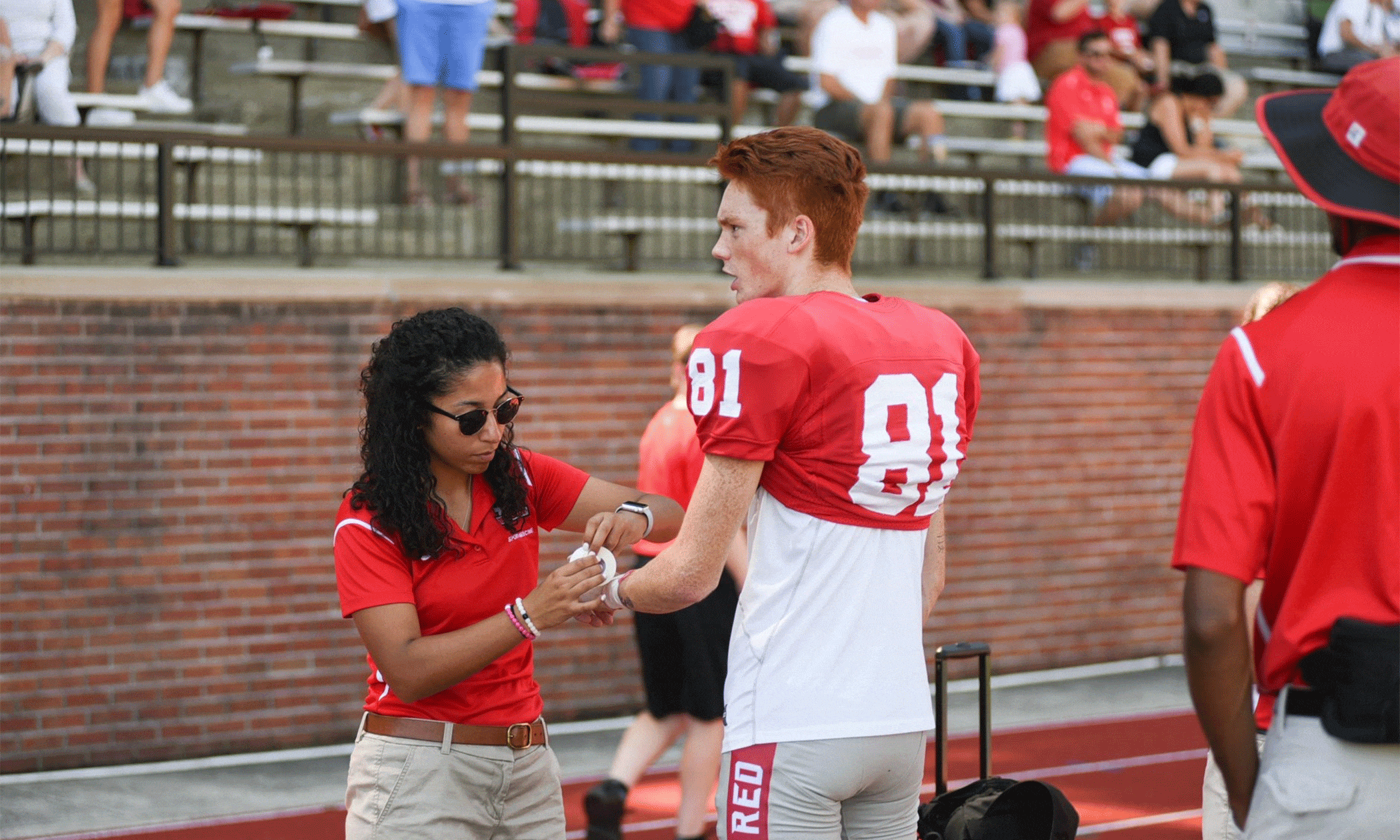 Photo of Maddox helping a football player