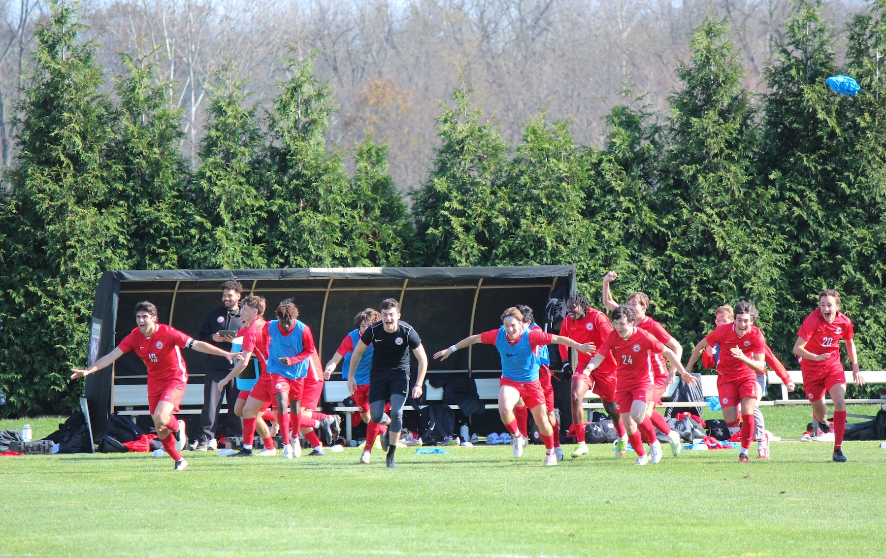 Members of the men’s soccer team run off the bench to celebrate a conference tournament championship. (Shannon O’Brien)