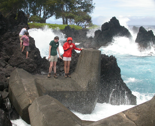 Brianne Jacoby and Liz Hopkins get drenched while examining a breakwater on the windward shore